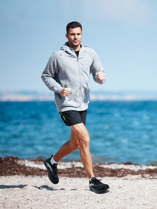 A man is running in the road wearing black running shoes